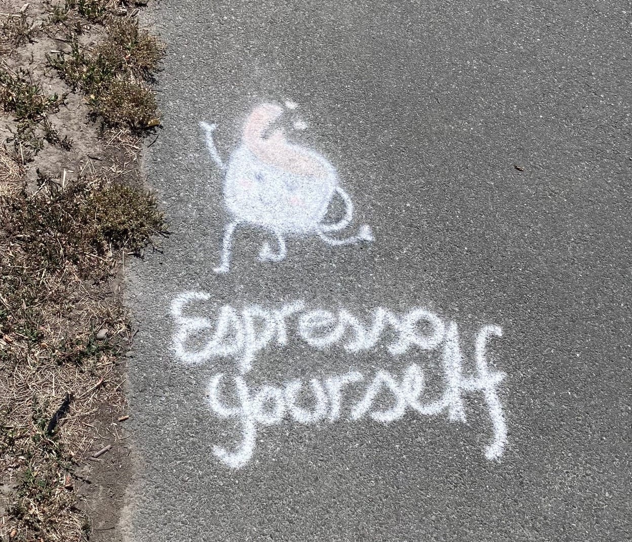 A chalk coffee cup with arms and legs and a splash of brown coffee in the shape of a quiff with the words "Espresso yourself"