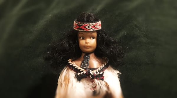 A plastic doll souvenir of a Māori girl in traditional clothing.